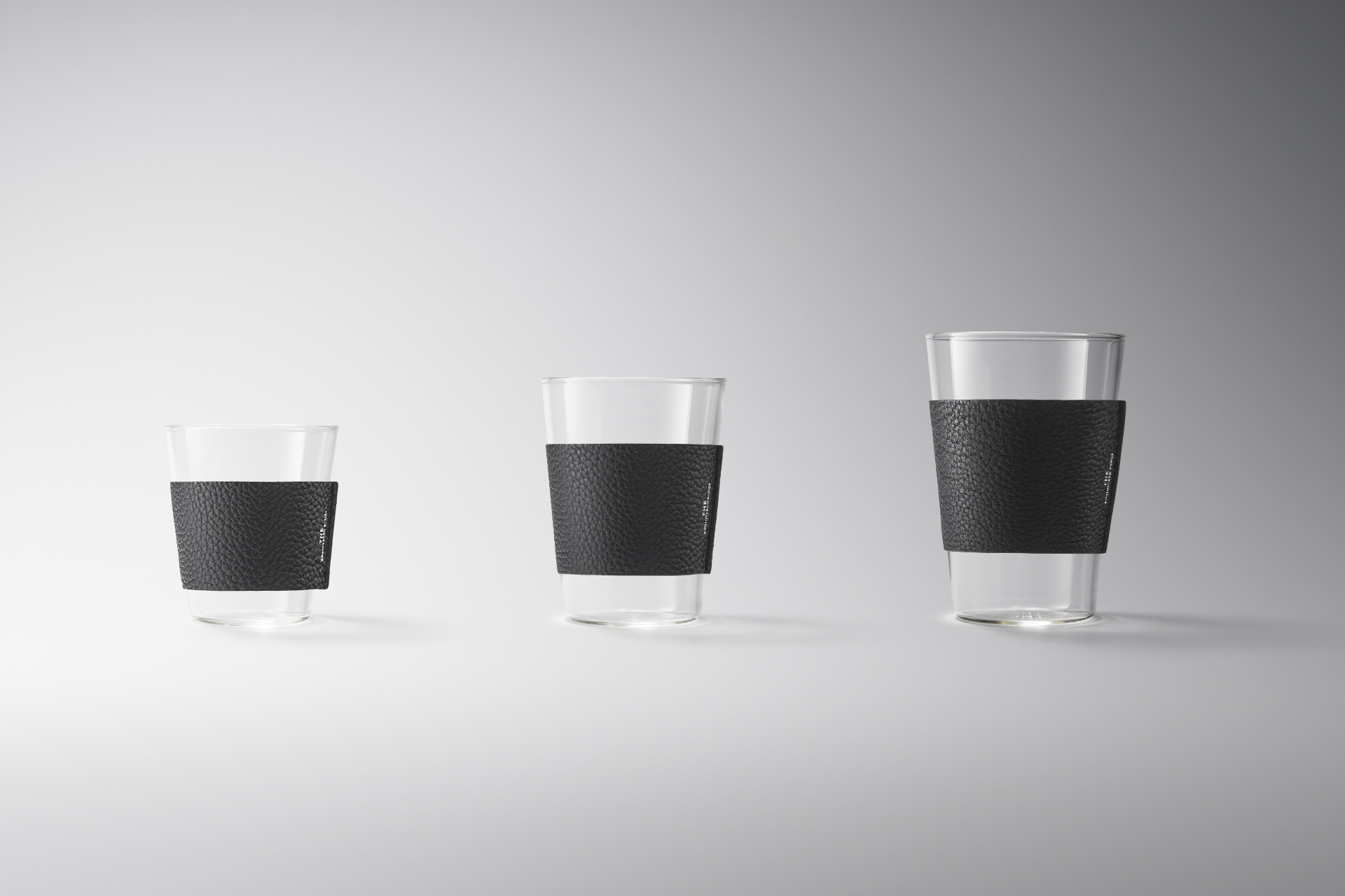 明亮背景中,SHORT、TALL、GRANDE 三只 THE GLASS 分別套上黑色牛革杯套,完整呈現三種尺寸。